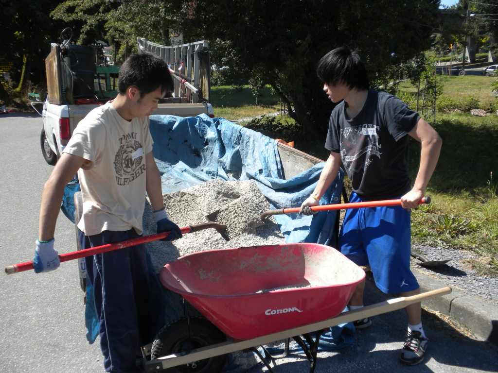 Shovelling gravel to prepare the base for the benches